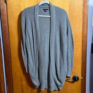Gray cardigan with pockets. Has hole details on both sleeves.